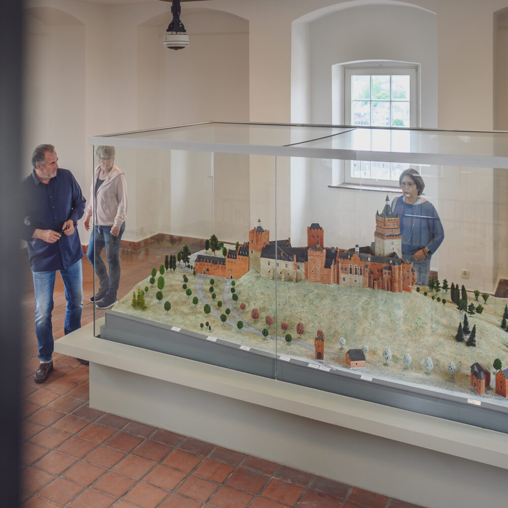 Personen betrachten das Modell der Schwanenburg