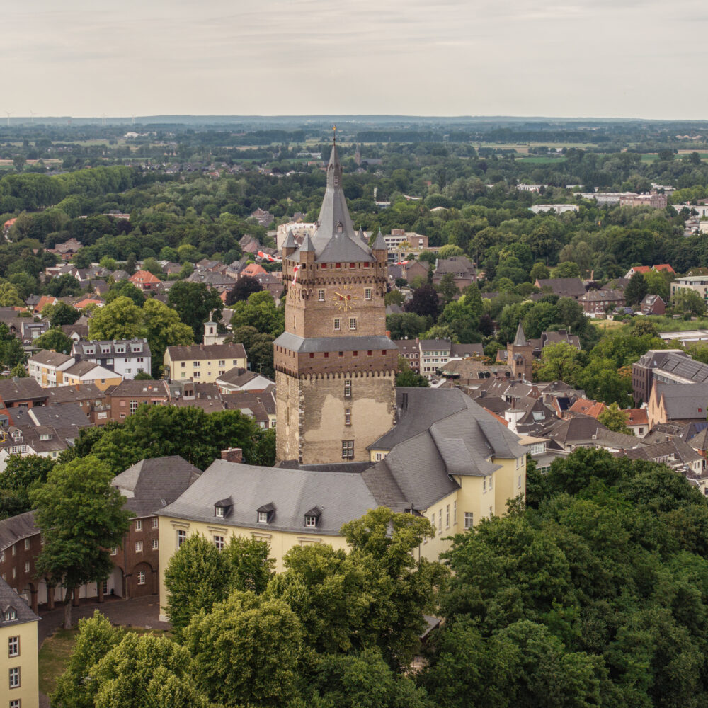 Blick aus der Luft auf die Schwanenburg inmitten der Stadt Kleve mit Bäumen im Vordergrund