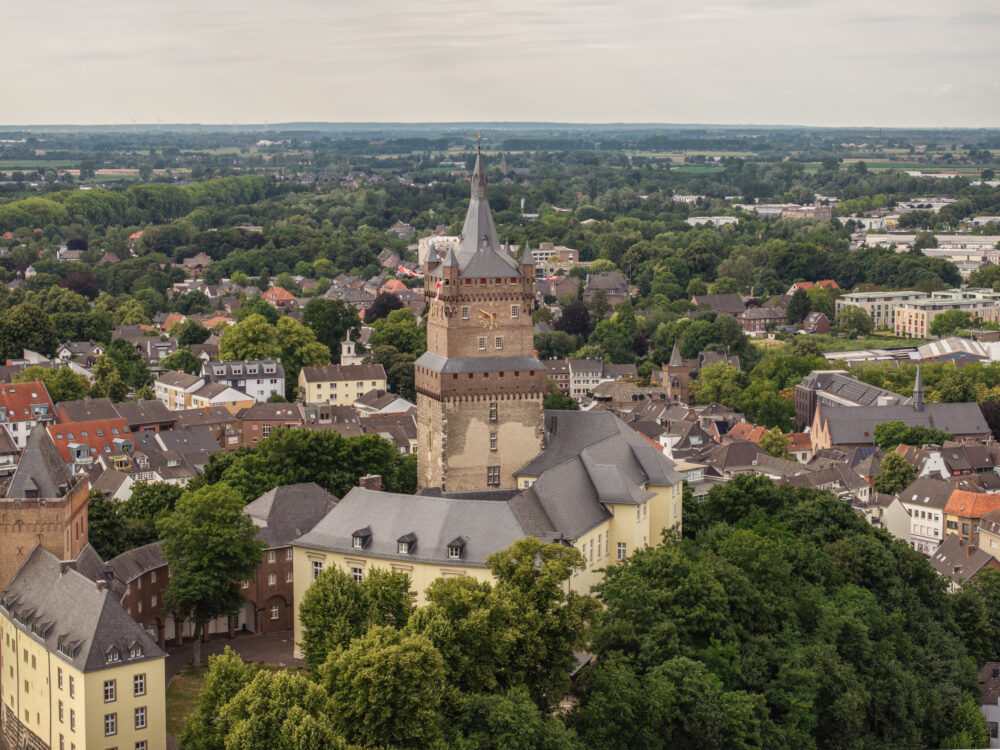 Blick aus der Luft auf die Schwanenburg inmitten der Stadt Kleve mit Bäumen im Vordergrund