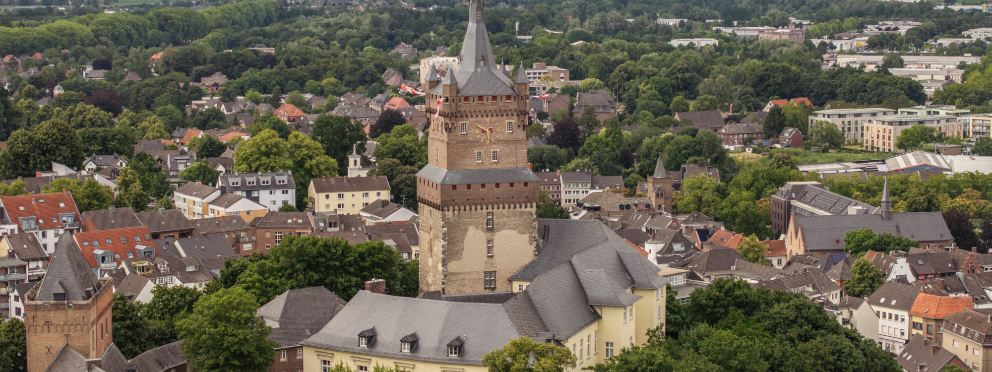 Blick aus der Luft auf die Schwanenburg inmitten der Stadt Kleve mit Bäumen im Vordergrund